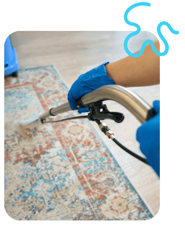 Technician performing professional carpet steam cleaning in a St. Johns County home using hot water extraction equipment.
